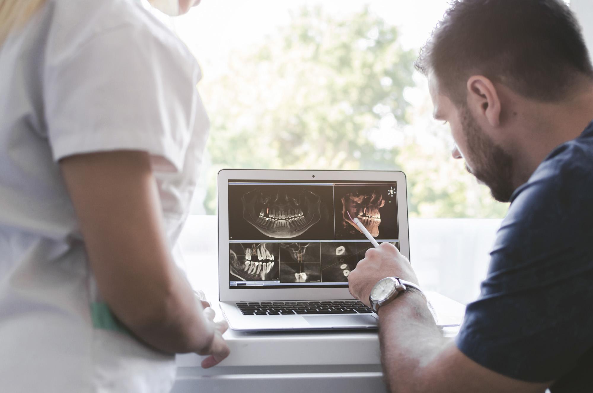 orthodontiste qui examine un scanner des dents